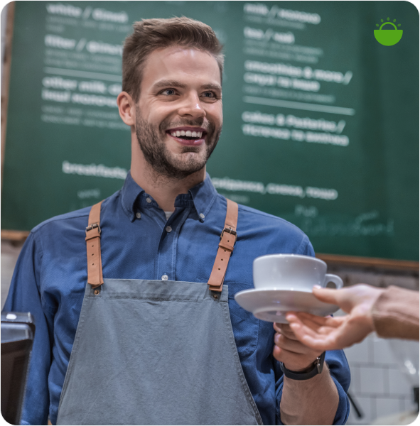 Barista handing a coffee to a customer in a cafe